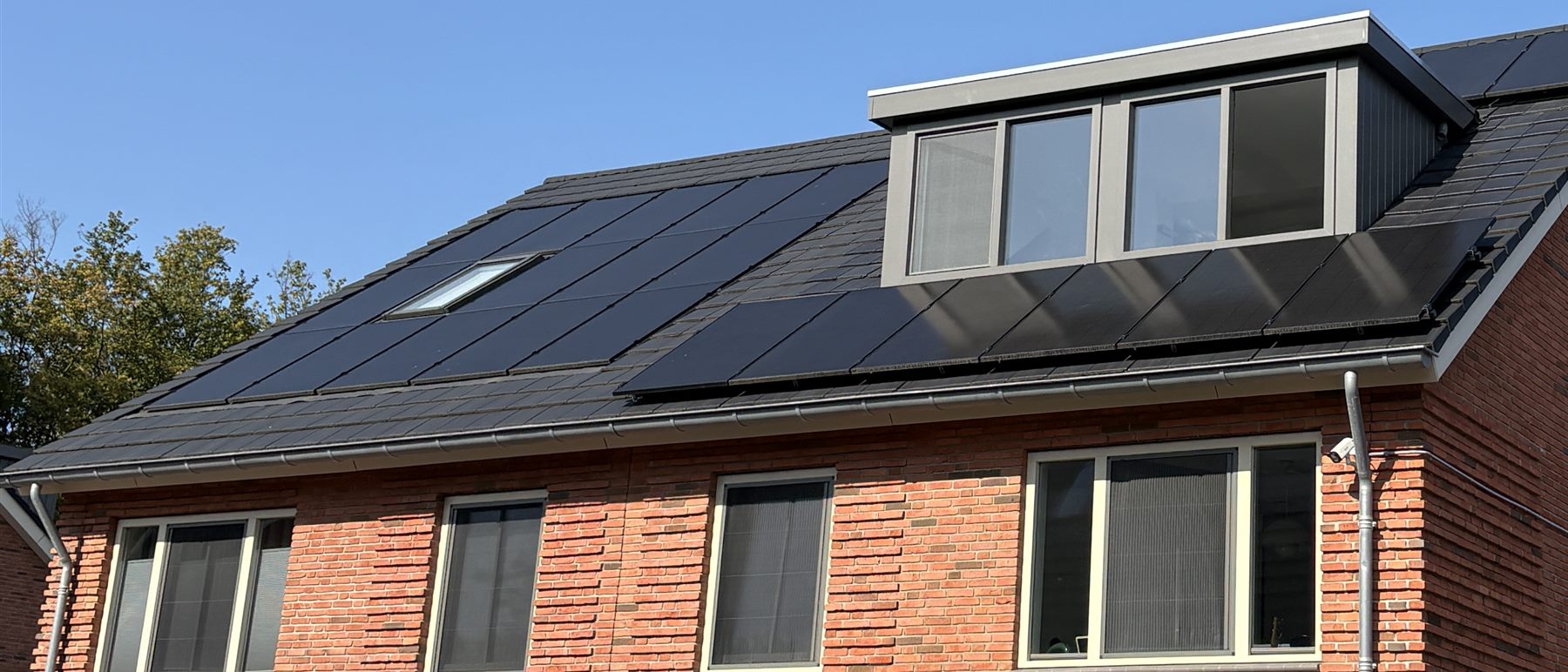 Indak gemonteerde zonnepanelen op een hellend pannendak met dakkapel, strak in het dakvlak weggewerkt